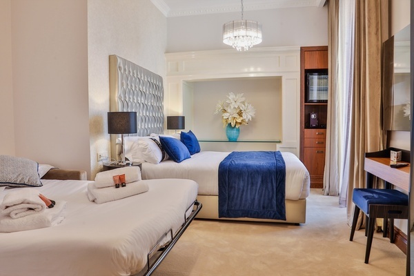 una habitación de hotel con dos camas y una mesa