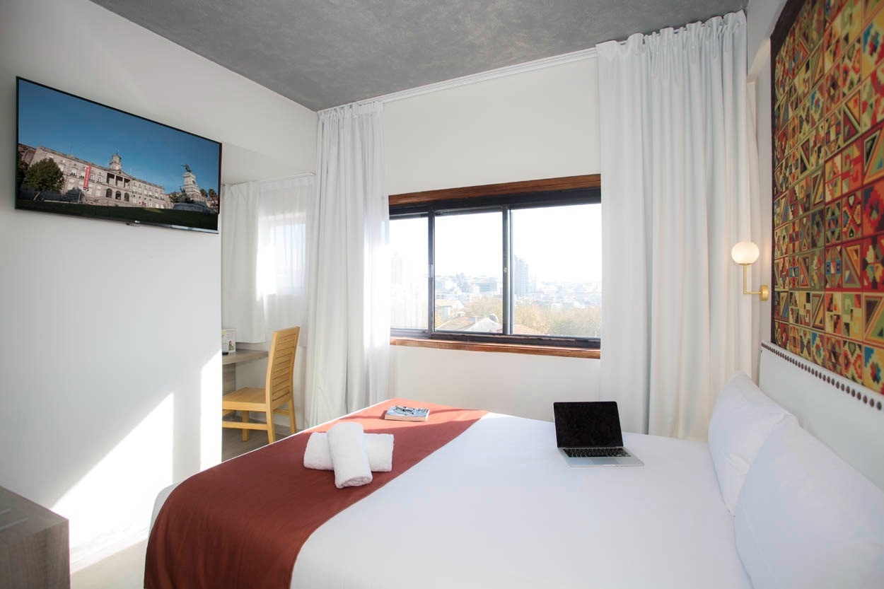 Modernes Hotelzimmer im Casual Inca Porto: Bett, Fenster & TV.