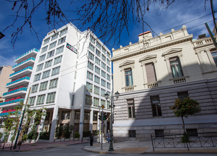 Classic Hotels: Modern white building on a city street, next to a historic classical building.