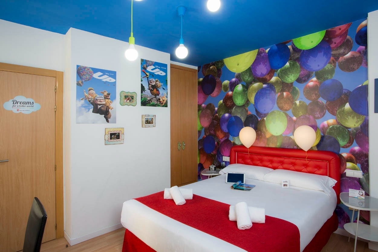 Themenzimmer im Casual del Cine Valencia mit Ballon-Wandgemälde und bequemen Bett.