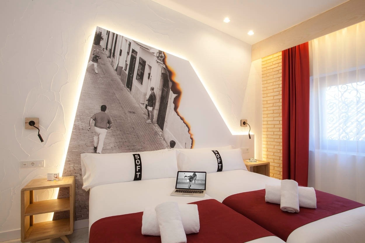 Habitación doble moderna en Casual Socarrat Valencia, con mural urbano y luz indirecta.