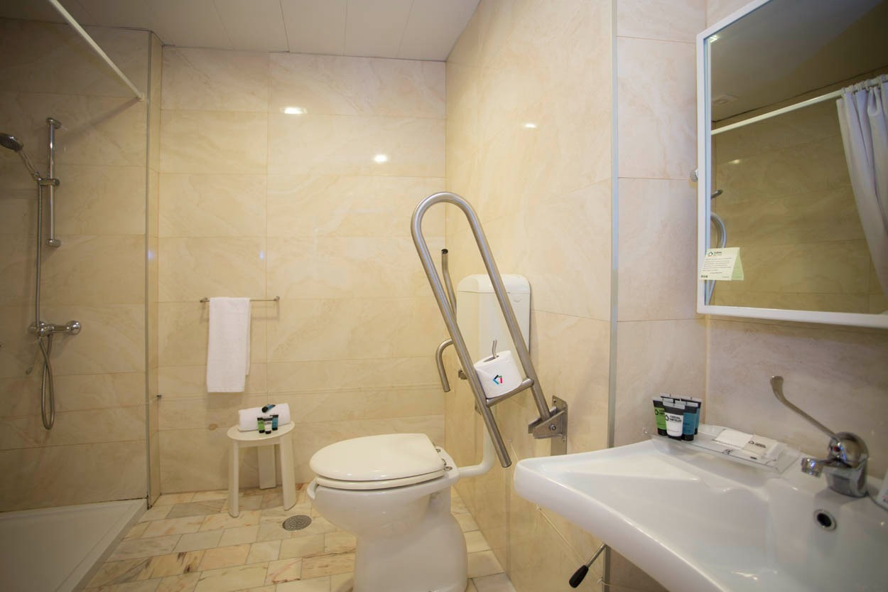 Barrierefreies Badezimmer im Casual Inca Porto – Hotel mit Dusche, WC und Waschbecken.