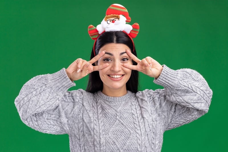 a woman wearing a santa headband making a peace sign