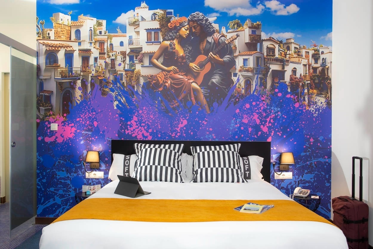 Cama matrimonial con mural vibrante en Casual Ilbira Granada. Hotel boutique céntrico.