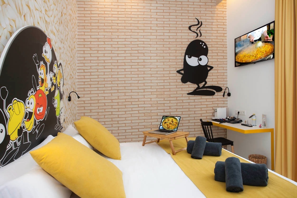 Habitación temática con dibujos animados y paella en TV, estilo Casual Valencia.