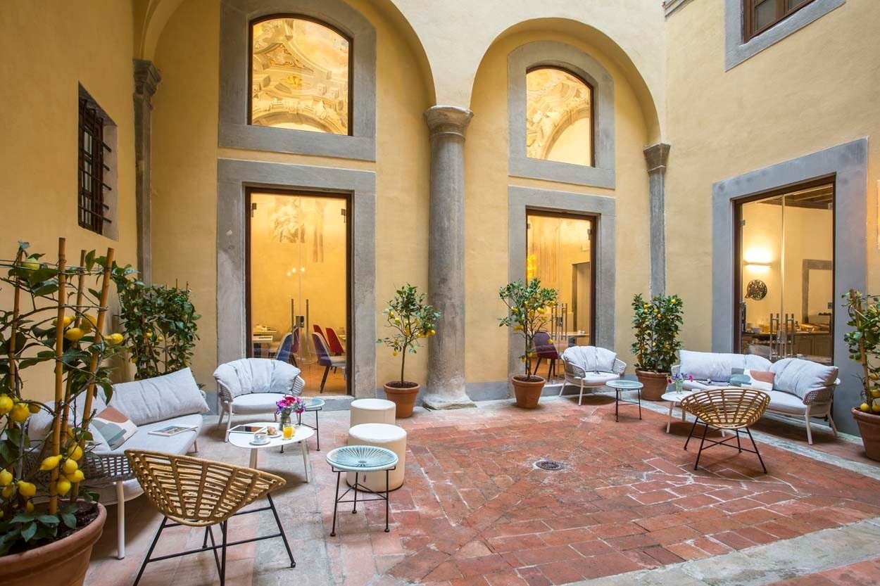 Garten-Lounge im Casual Rinascimento Firenze: Entspannter Innenhof mit Sitzmöbeln und Zitrusbäumen in Florenz.