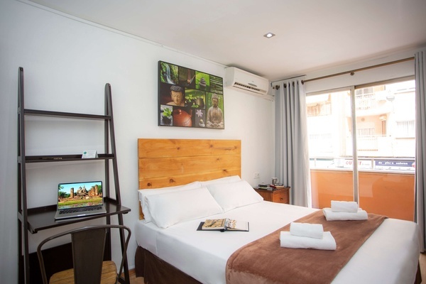 una habitación con una cama y una computadora portátil