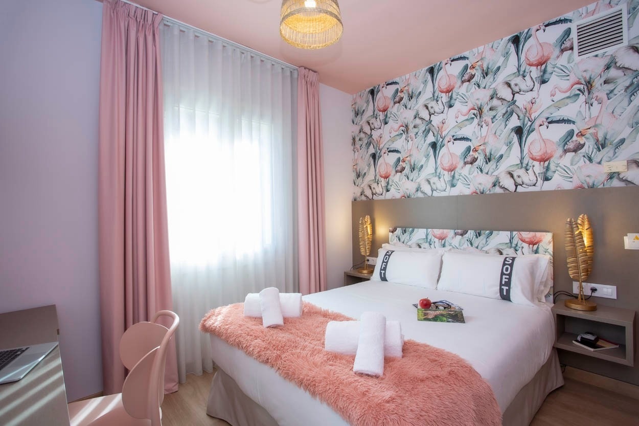 Casual Colours Barcelona: een hippe hotelkamer met tropische flamingo behang en zachtroze accenten.