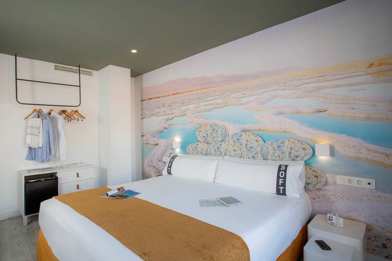 Modernes Hotelzimmer im Casual del Mar Málaga mit Bett & Wandgemälde.