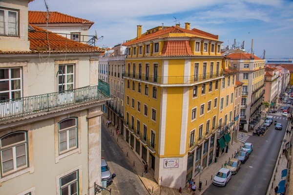 un edificio amarillo está al lado de un edificio blanco