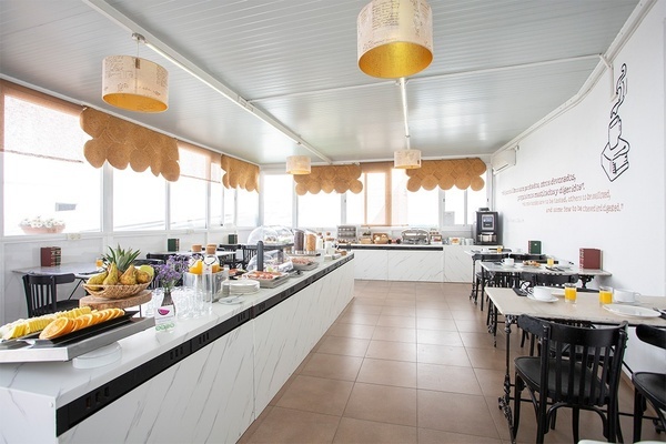 une salle à manger avec des tables et des chaises et un mur avec une phrase en espagnol