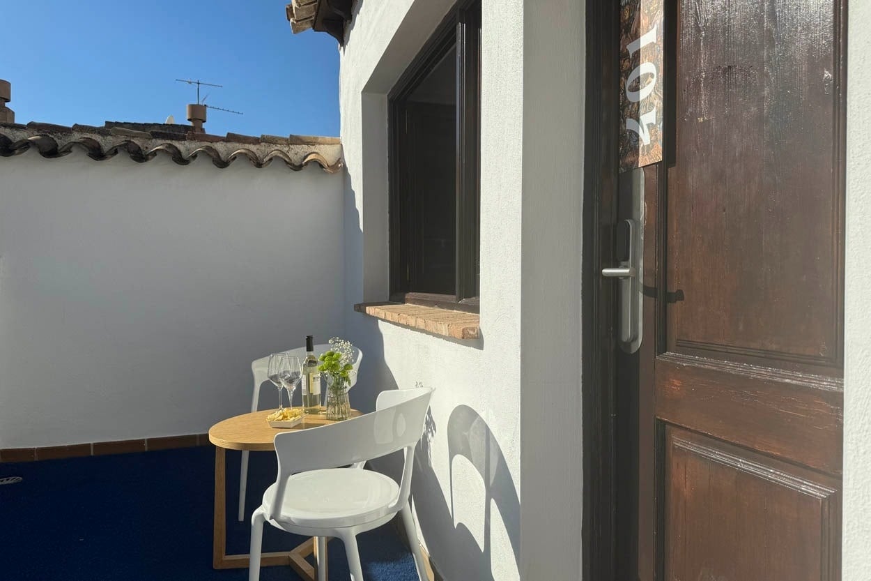 Terraza privada con mesa y sillas, vino y aperitivos. Casual Ilbira Granada.