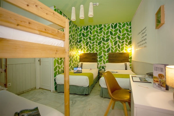 a room with green leaves on the wall and bunk beds
