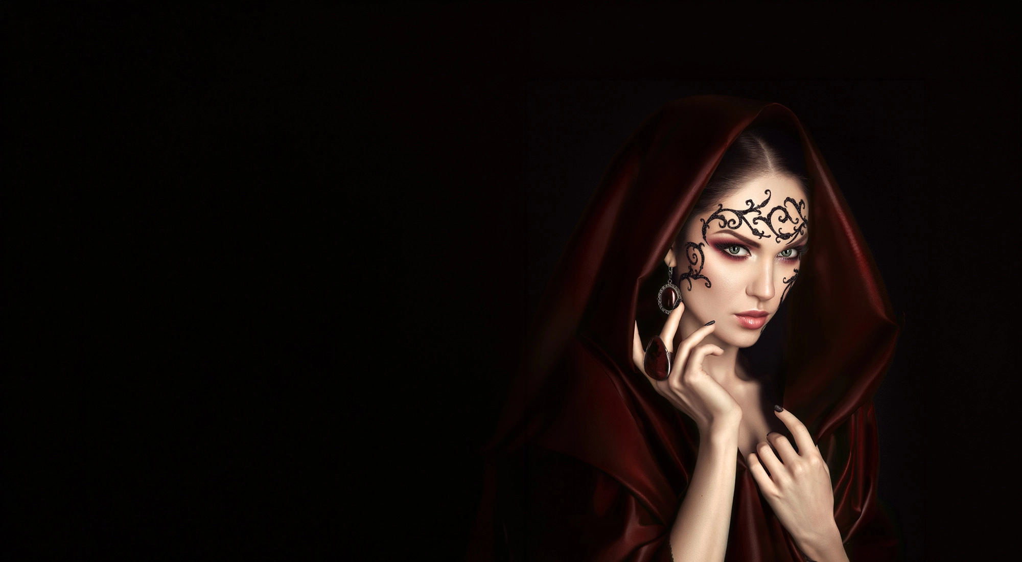 Mujer misteriosa con capa roja y maquillaje llamativo, perfecta para un ambiente de Casual Hoteles