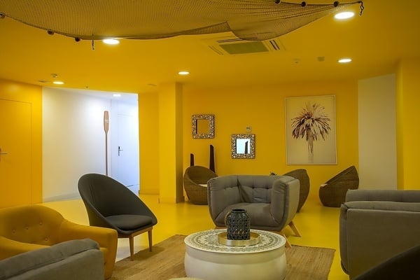 una sala de estar con paredes amarillas y sillas y una mesa