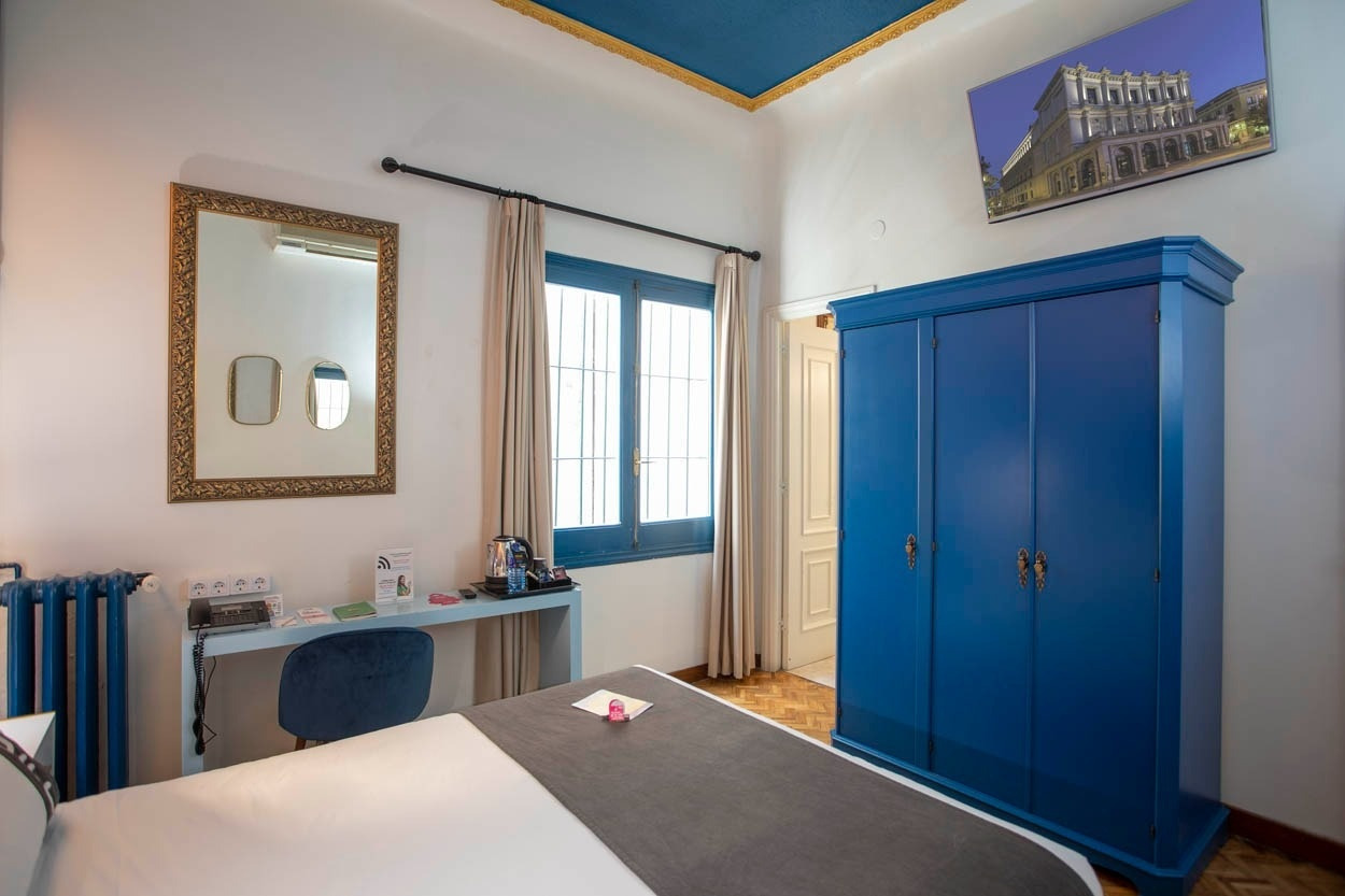 Gemütliches Schlafzimmer mit blauem Kleiderschrank im Casual del Teatro Madrid - Boutique-Hotel nahe der Gran Vía.