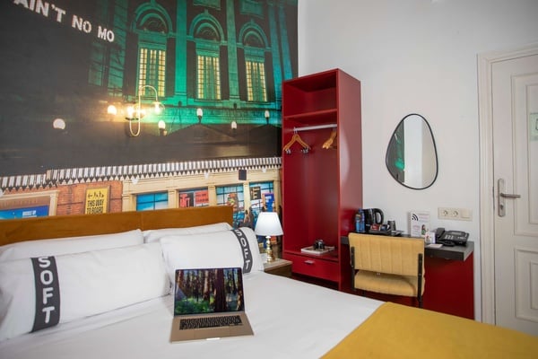 een laptop zit op een bed met een kussen dat zegt soft