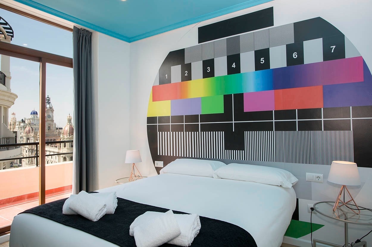 Habitación moderna con mural de televisión vintage en Casual Vintage Valencia, hotel céntrico.