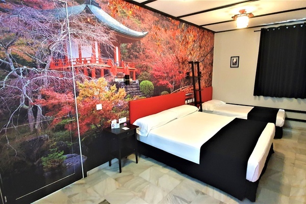 a bedroom with two beds and a painting on the wall