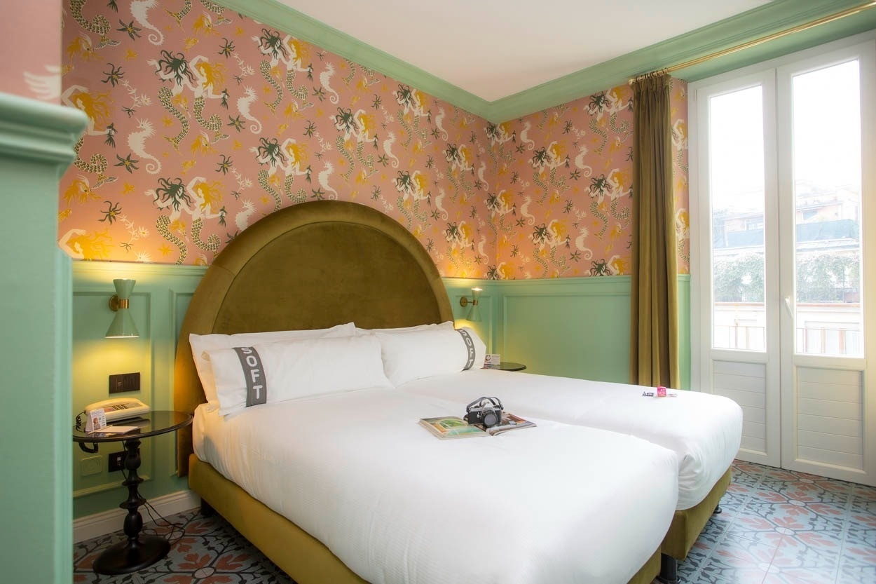 Gemütliches Zimmer im Casual Eclettico Milano – Hotel Mailand Nähe Bahnhof Centrale mit verspielter Tapete und bequemen Betten.