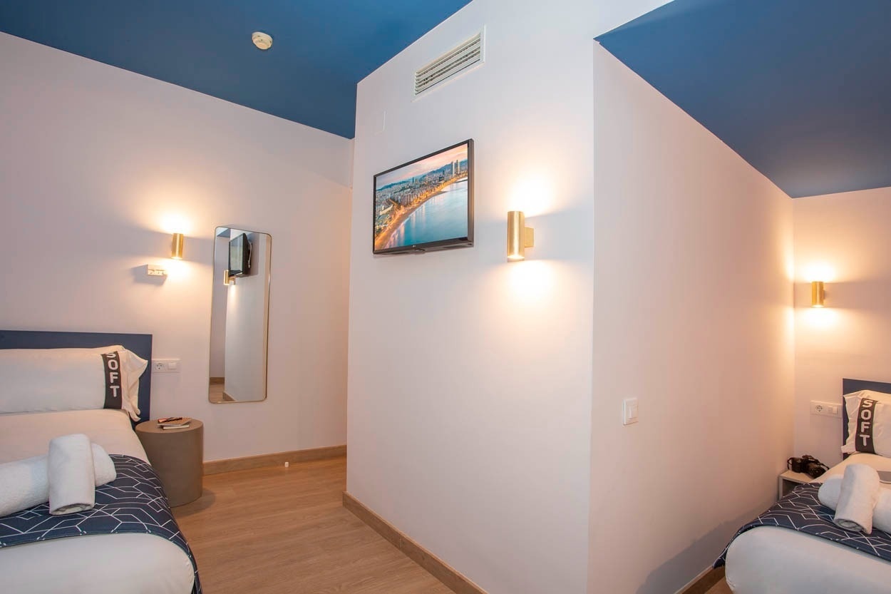 Moderne hotelkamer met tweepersoonsbed en blauw plafond bij Casual Colours Barcelona - Hotel nabij Sants, Barcelona.