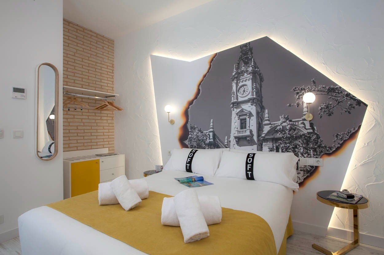 Habitación en Casual Socarrat Valencia con mural de torre y detalles acogedores.