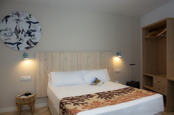 a bedroom with a painting of whales on the wall above the bed