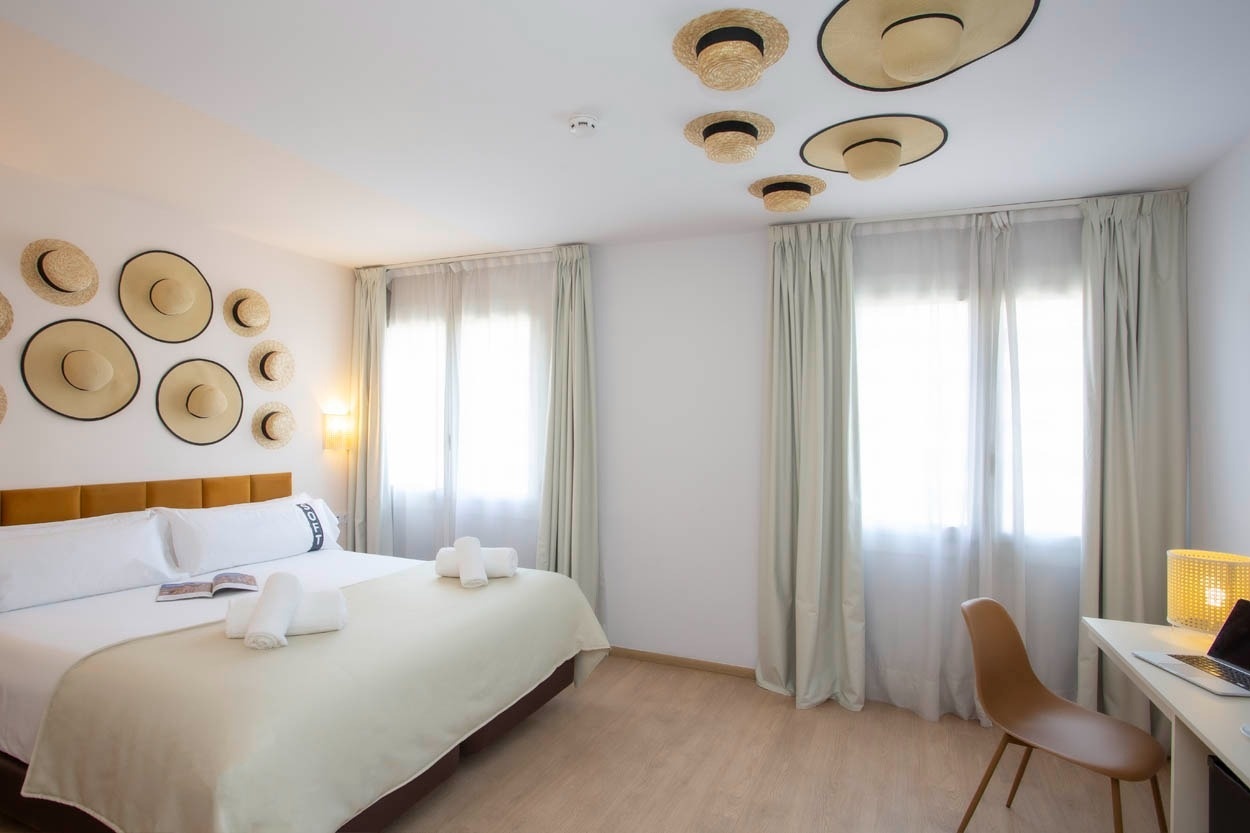 Casual Colours Barcelona: Tropische kamer met strohoeden decoratie en comfortabel bed. Ideaal voor uw verblijf in Barcelona.