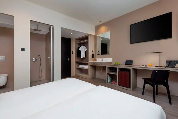 een hotelkamer met twee bedden en een televisie