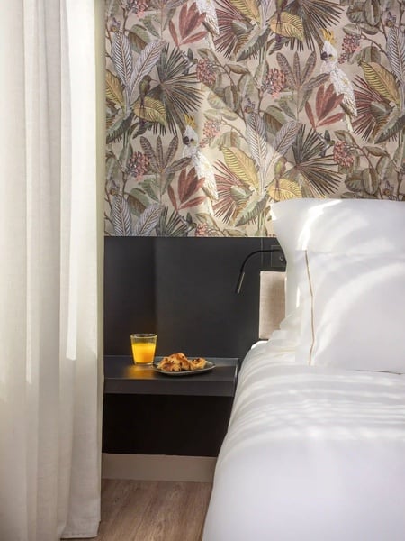 een bed met een bord koekjes en een glas sinaasappelsap op een nachtkastje