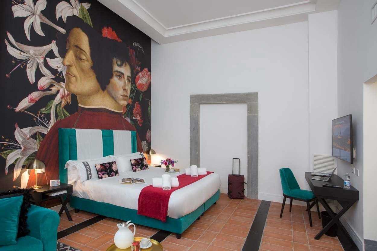 Modernes Hotelzimmer im Casual Rinascimento Firenze: Bett mit Kunst-Wandgemälde, Schreibtisch, TV.