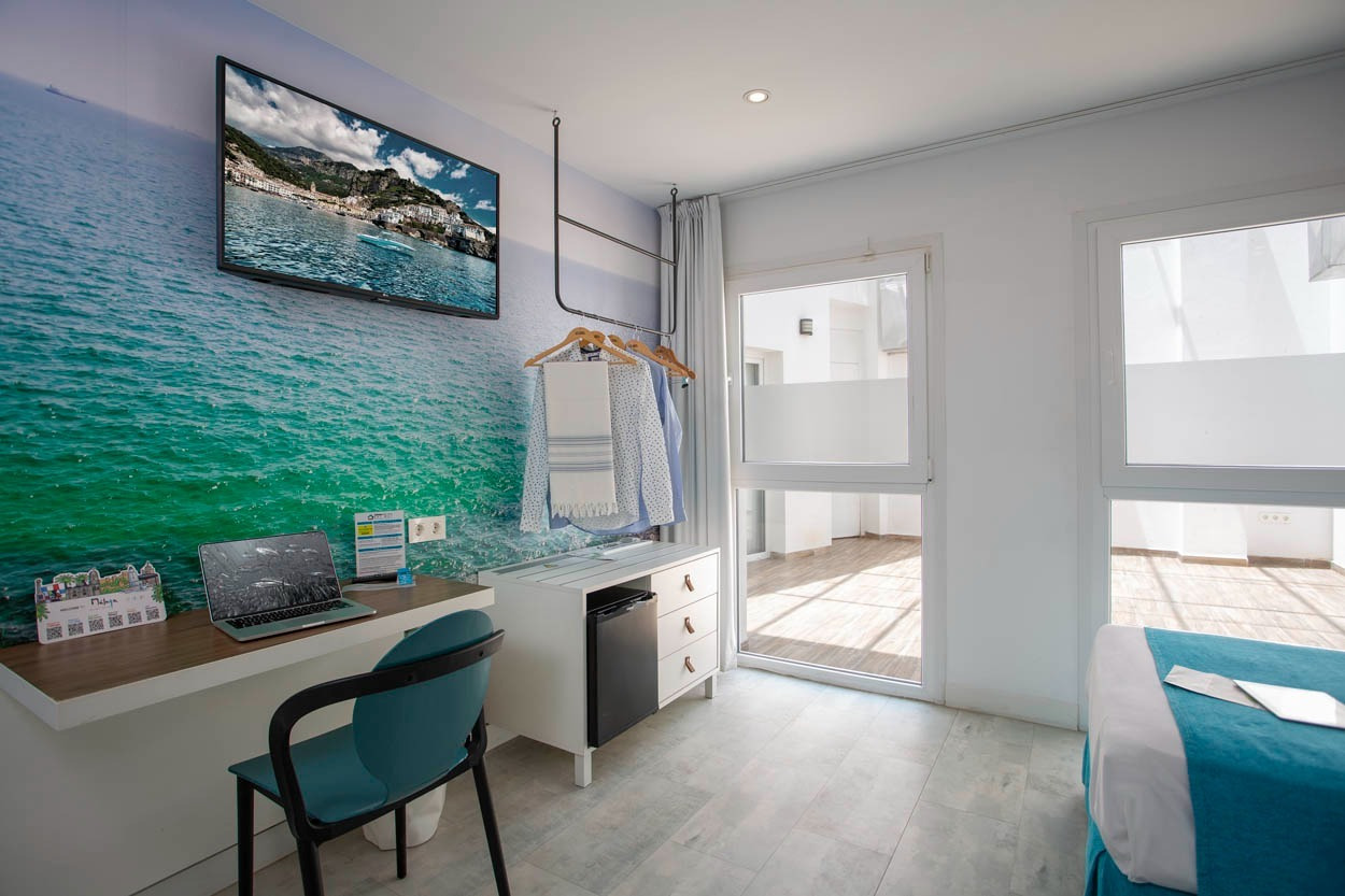 Modernes Hotelzimmer im Casual del Mar Málaga mit Meerblick-Wandbild und Schreibtisch.
