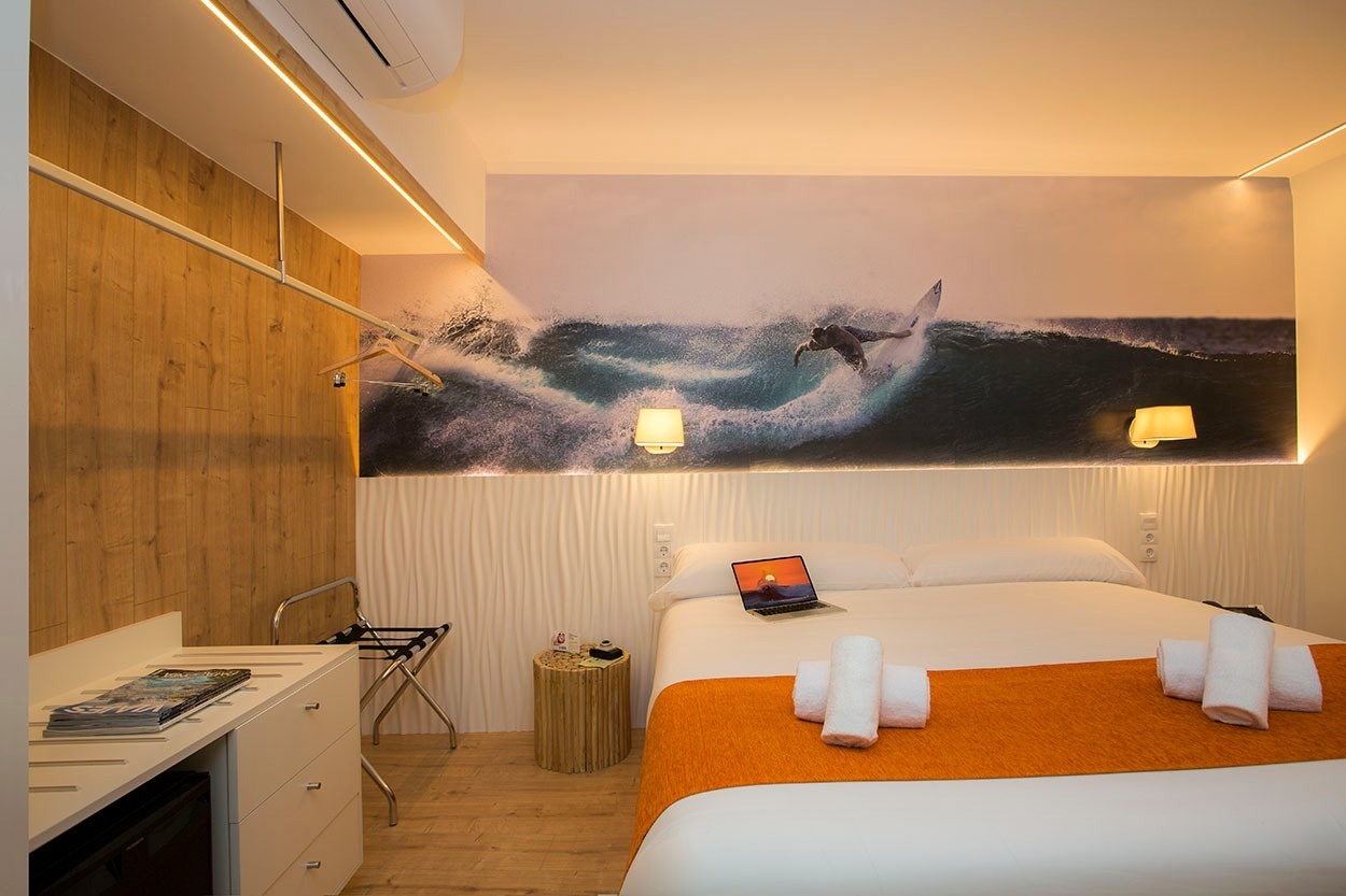 Modernes Zimmer mit Surfer-Mural im Casual de las Olas San Sebastián – Themenhotel