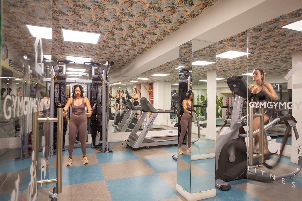 Fitnessbereich im Casual Kubic Athens - Smart Hotel, mit Cardio-Geräten und Gewichten.