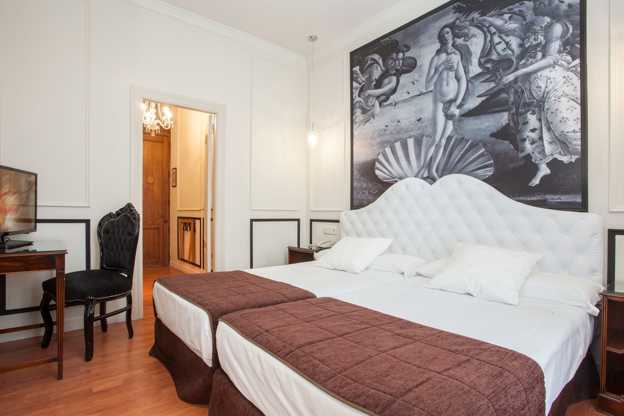 una habitación con dos camas y una pintura en la pared