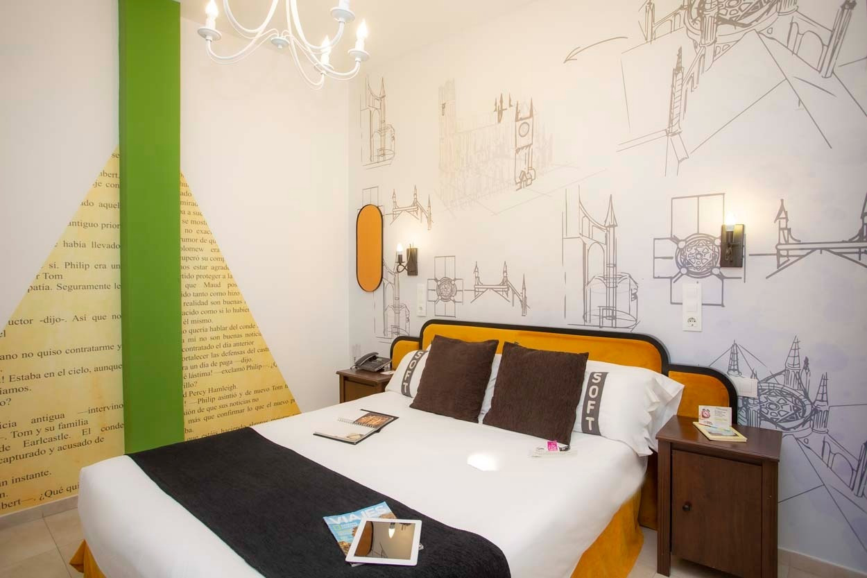 Gemütliches Zimmer mit Buchmotiv & Skizzen von Gebäuden im Casual de las Letras Sevilla.