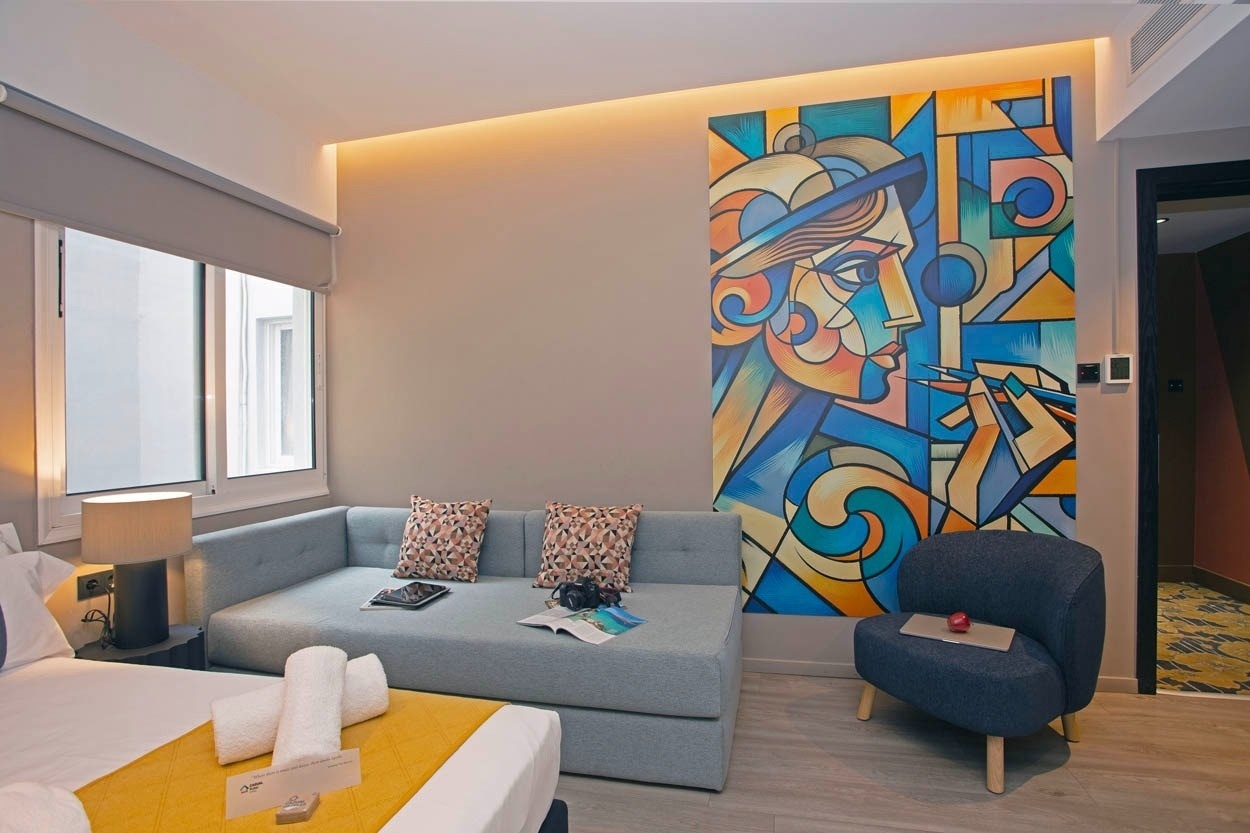Casual Kubic Athens: Stylisches Hotelzimmer mit kubistischem Gemälde, modernem Sofa und Fensterblick.