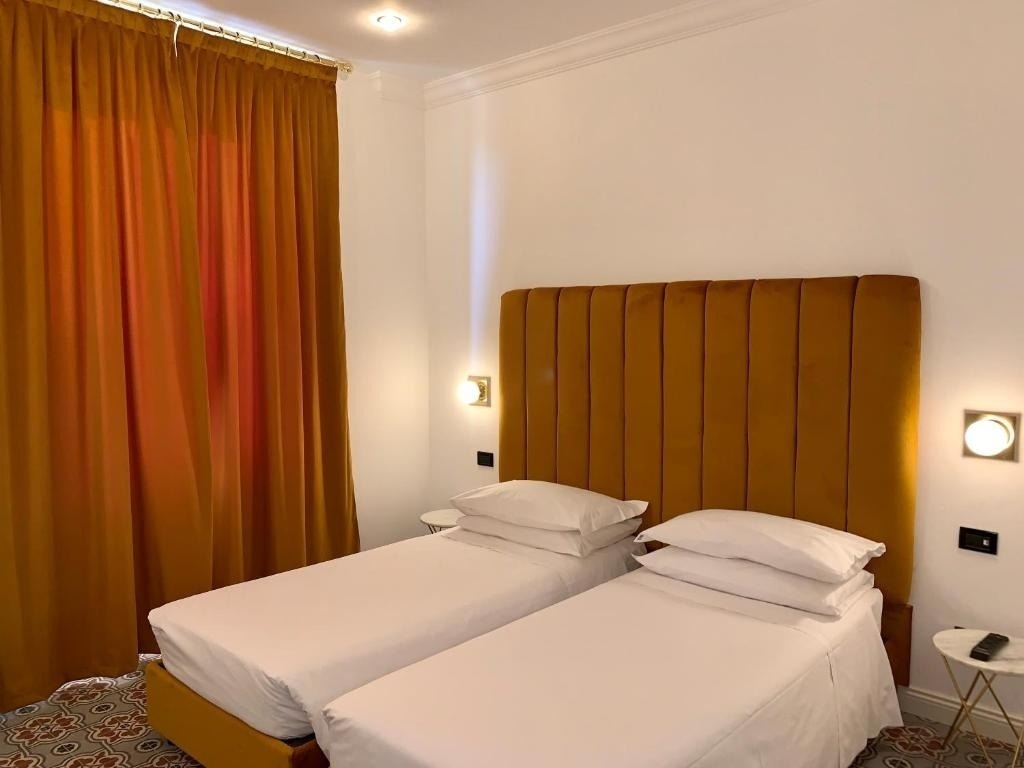 a bedroom with two beds and a yellow headboard