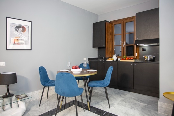 a kitchen with a table and chairs and a picture on the wall