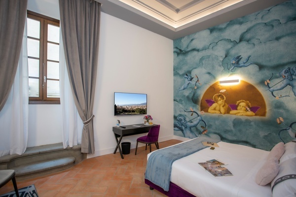 a bedroom with a painting of cherubs on the wall