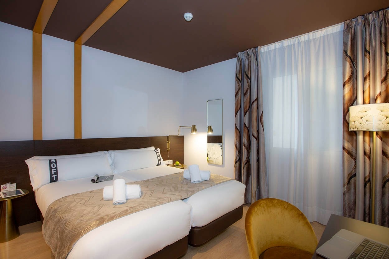 Comfortabele tweepersoonskamer met moderne accenten en 'Casual Colours Barcelona - Hotel nabij Sants' in het zicht.