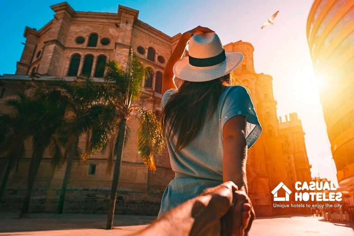 a woman holding a man 's hand in front of a building that says casual hotels