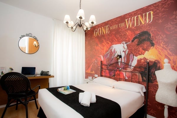 una habitación con una cama y un cartel de gone with the wind
