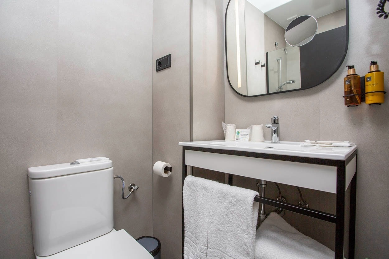 Modernes Badezimmer mit Dusche, Waschbecken und WC. Im Casual del Cine Valencia - Themenhotel in Valencia.
