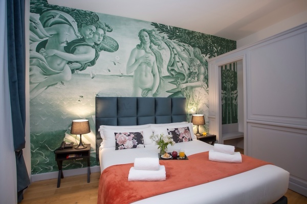 a bedroom with a bed and a painting on the wall