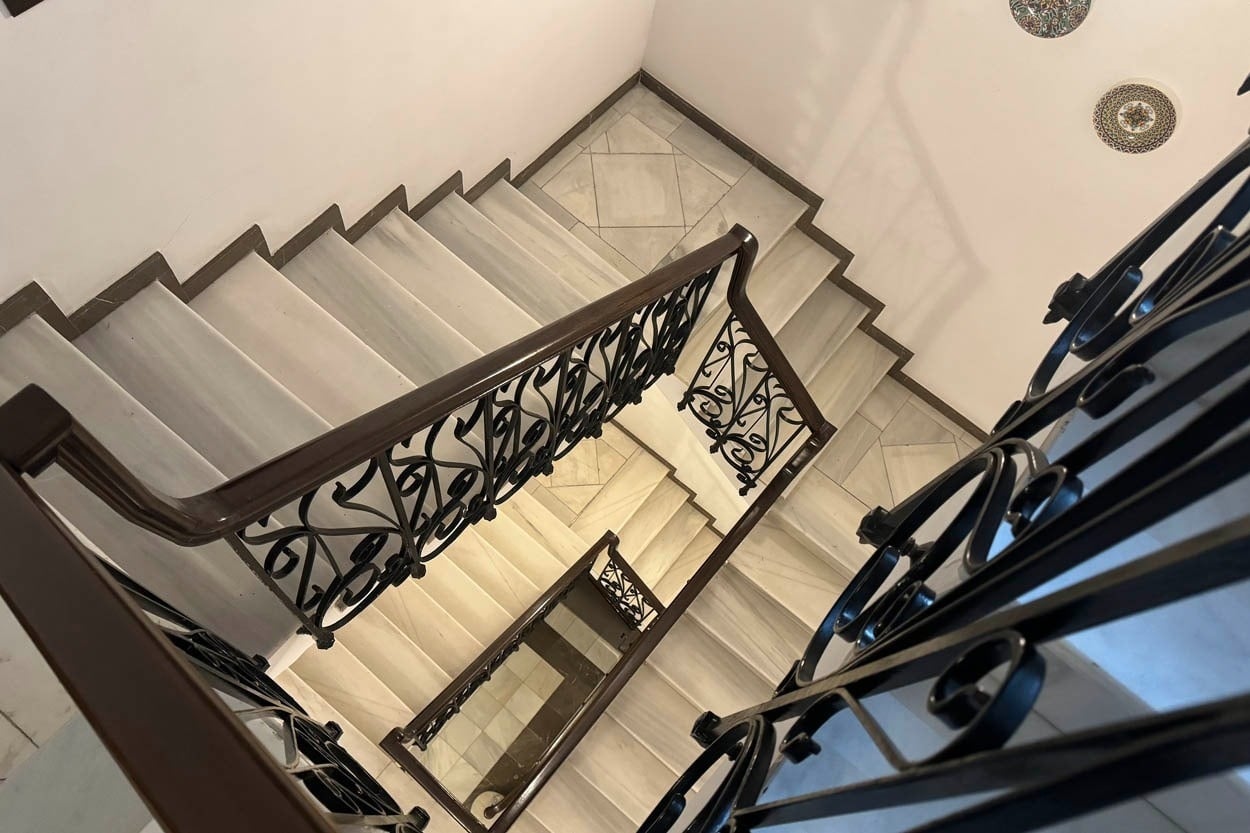 Escaleras de mármol con barandillas de hierro forjado en Casual Ilbira Granada - Hotel boutique.