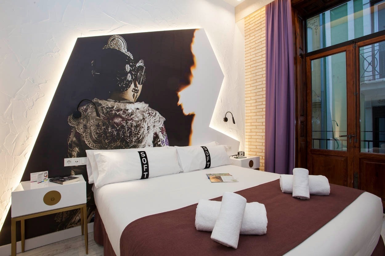 Habitación moderna en Casual Socarrat Valencia con cama cómoda y arte llamativo.