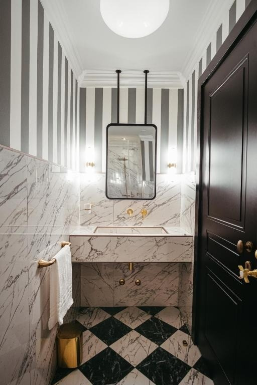 a bathroom with striped walls and a checkered floor