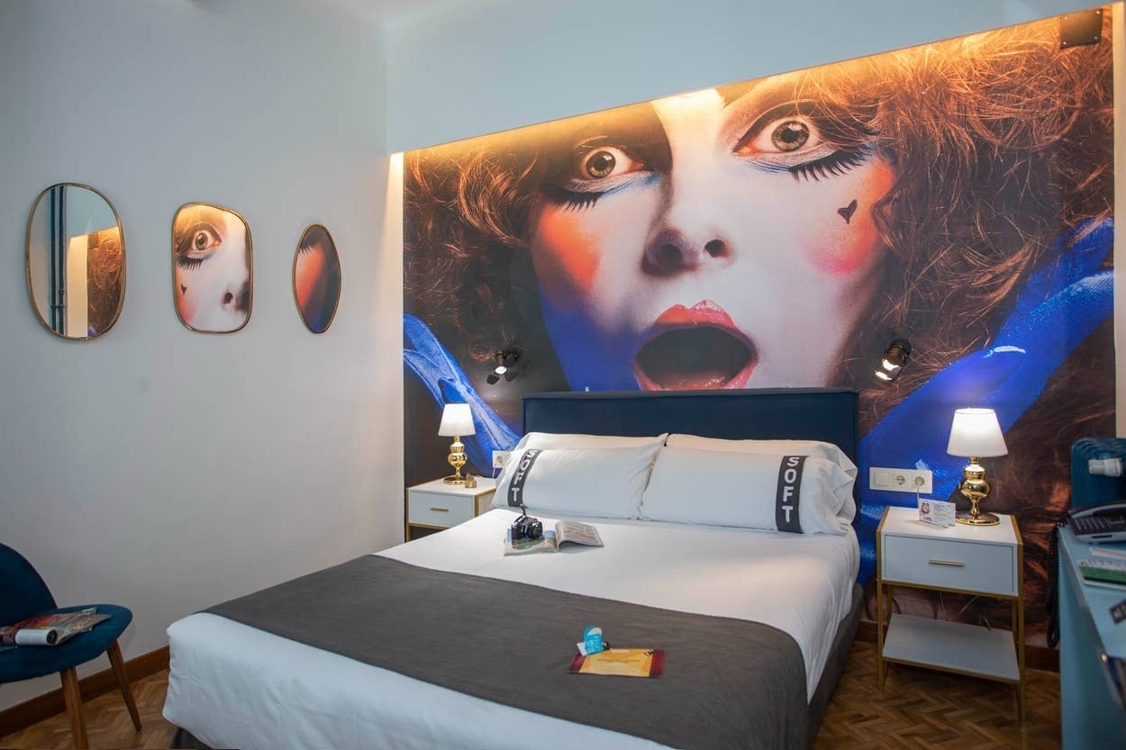 Gemütliches Zimmer im Casual del Teatro Madrid, mit Kunstwerk und Doppelbett.