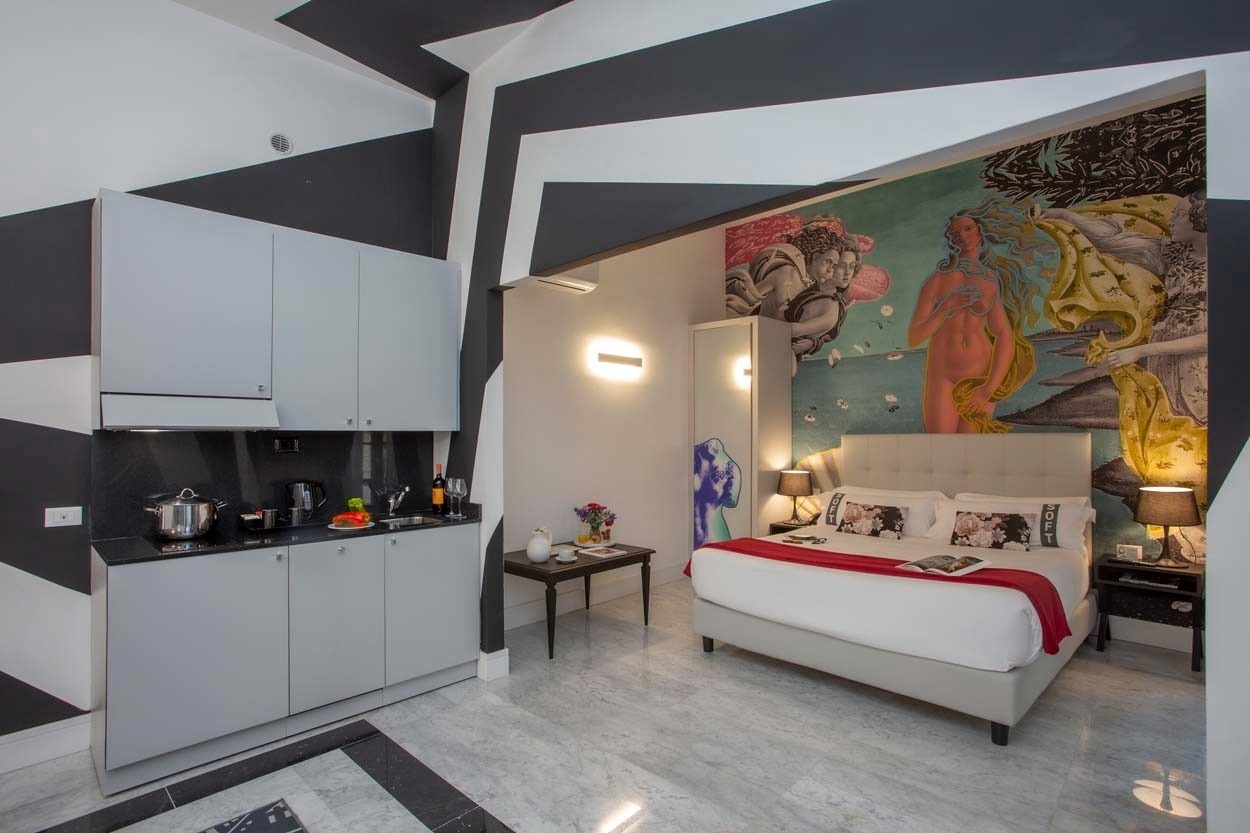 Modernes Hotelzimmer im Casual Rinascimento Firenze mit Kunstwandgemälde und Kochnische.